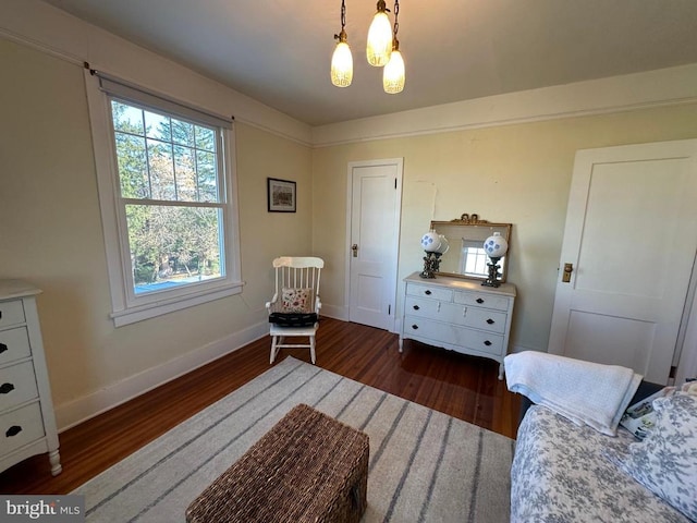 bedroom with wood finished floors, baseboards, and a chandelier