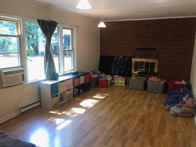 109 Cooper Dr, Stuarts Draft, VA 24477 - living area featuring a baseboard heating unit, wood finished floors, a brick fireplace, cooling unit, and brick wall