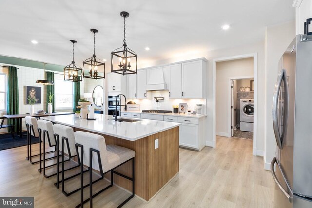 10103 N Streamview Ct, Fredericksburg, VA 22408 - kitchen featuring stainless steel appliances, a sink, a chandelier, washer / clothes dryer, and white cabinets