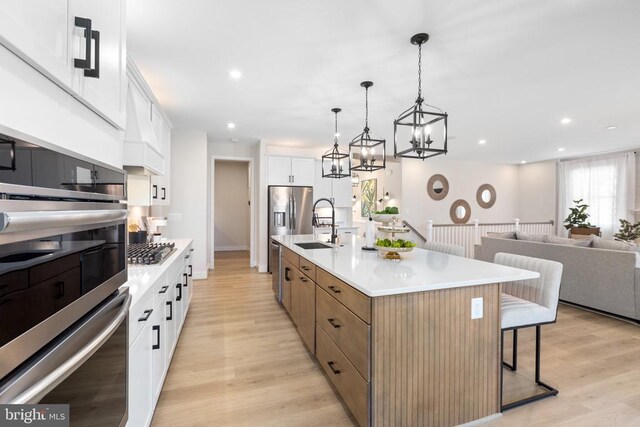 10103 N Streamview Ct, Fredericksburg, VA 22408 - kitchen with stainless steel appliances, a breakfast bar, white cabinets, light wood-type flooring, and recessed lighting