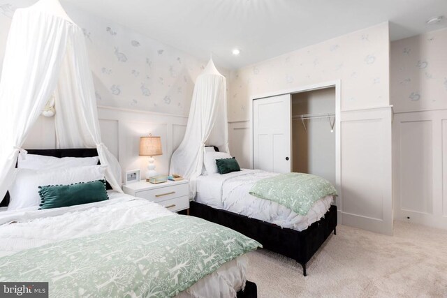 10103 N Streamview Ct, Fredericksburg, VA 22408 - bedroom featuring wallpapered walls, a decorative wall, a wainscoted wall, a closet, and light colored carpet