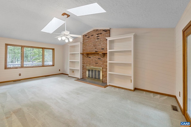 7 Spoon Ter, Palmyra, VA 22963 - unfurnished living room featuring a skylight, vaulted ceiling, a textured ceiling, carpet, and a fireplace