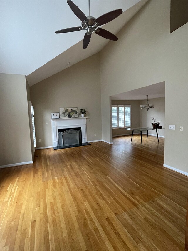 27 Shannon Pl Unit 27, Staunton, VA 24401 - unfurnished living room featuring high vaulted ceiling, a fireplace with raised hearth, ceiling fan, wood finished floors, and a chandelier