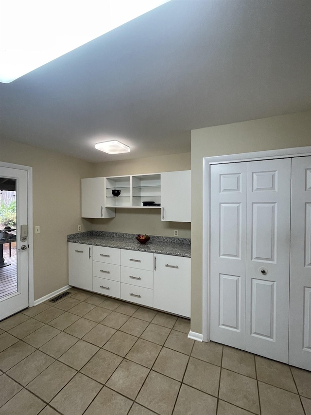 27 Shannon Pl Unit 27, Staunton, VA 24401 - kitchen with dark countertops, open shelves, light tile patterned floors, and white cabinets
