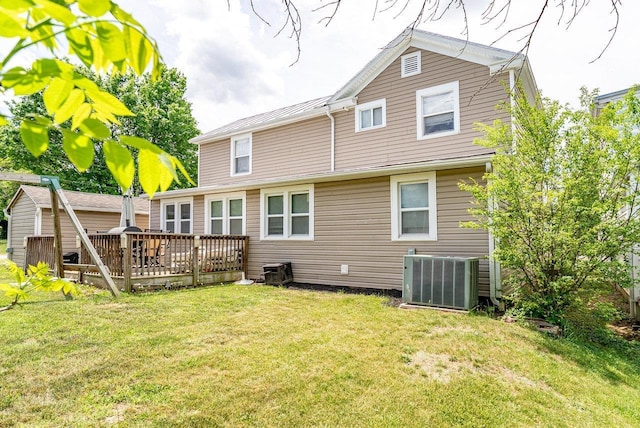 back of property featuring cooling unit, a wooden deck, and a lawn