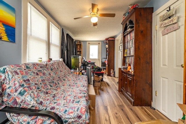 bedroom with wood finished floors, a textured ceiling, and a ceiling fan