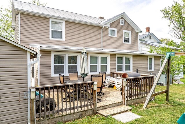 202 Jackson Ave, Elkton, VA 22827 - back of property featuring outdoor dining space, a wooden deck, metal roof, and a lawn