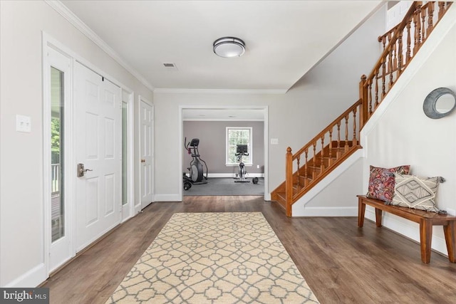  - foyer with dark wood-style flooring, stairway, and ornamental molding