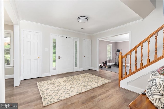  - foyer entrance with wood finished floors, stairs, and ornamental molding