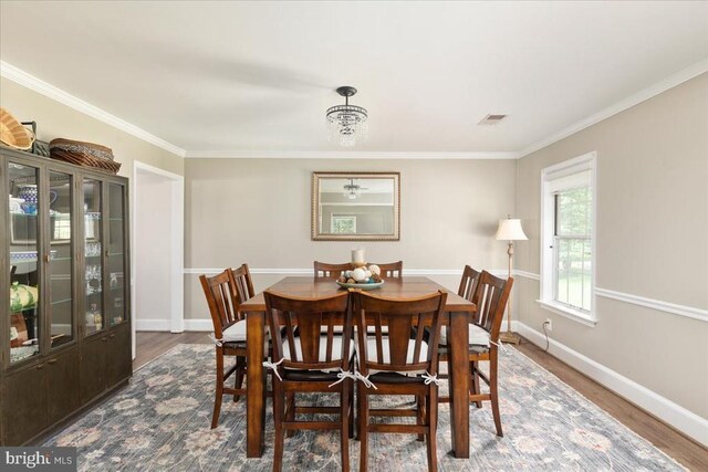  - dining room featuring dark wood finished floors and ornamental molding