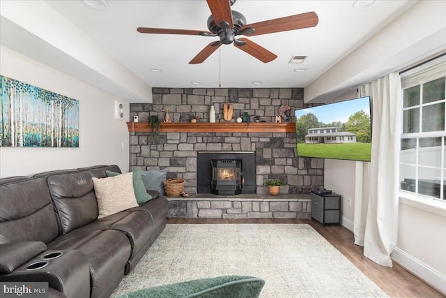  - living area with wood finished floors, a ceiling fan, and a fireplace