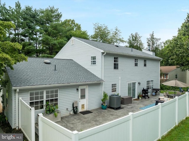  - rear view of property with a patio area, roof with shingles, and a chimney