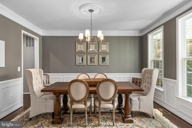 11219 Kailee Ln, Spotsylvania, VA 22553 - dining space featuring crown molding, a chandelier, wood finished floors, a decorative wall, and wainscoting