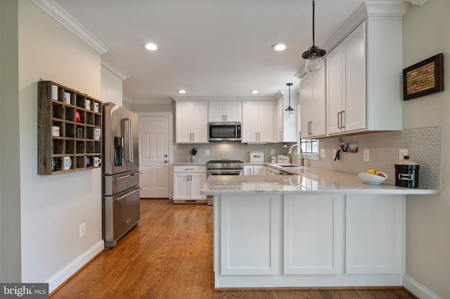 52 N St, Warrenton, VA 20186 - kitchen with appliances with stainless steel finishes, a peninsula, white cabinets, ornamental molding, and tasteful backsplash