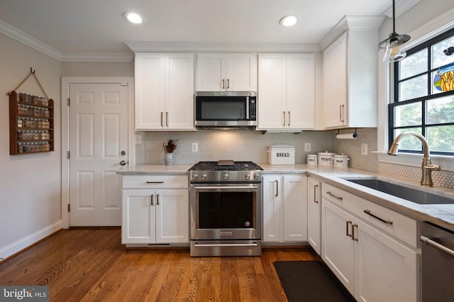 52 N St, Warrenton, VA 20186 - kitchen featuring stainless steel appliances, a sink, ornamental molding, white cabinetry, and decorative backsplash