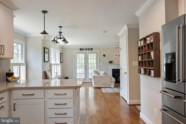 52 N St, Warrenton, VA 20186 - kitchen featuring stainless steel refrigerator with ice dispenser, a peninsula, wood finished floors, a glass covered fireplace, and white cabinetry
