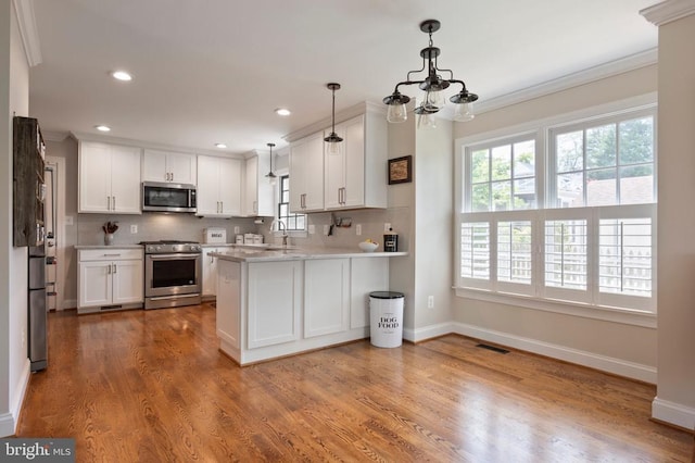 52 N St, Warrenton, VA 20186 - kitchen featuring appliances with stainless steel finishes, healthy amount of natural light, tasteful backsplash, ornamental molding, and recessed lighting