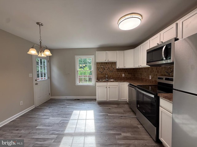 319 Chopping Rd, Mineral, VA 23117 - kitchen with stainless steel appliances, a chandelier, dark countertops, and white cabinetry