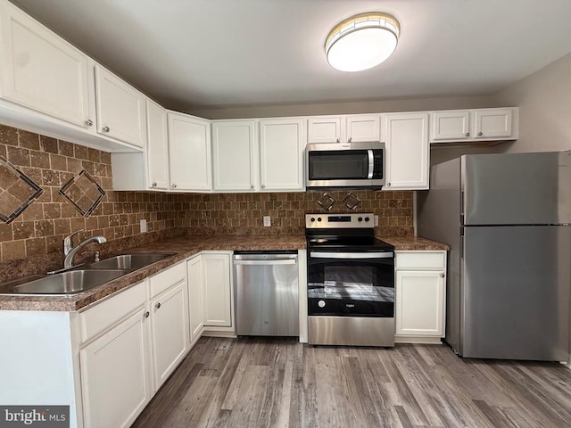 319 Chopping Rd, Mineral, VA 23117 - kitchen featuring stainless steel appliances, white cabinetry, light wood finished floors, decorative backsplash, and dark countertops