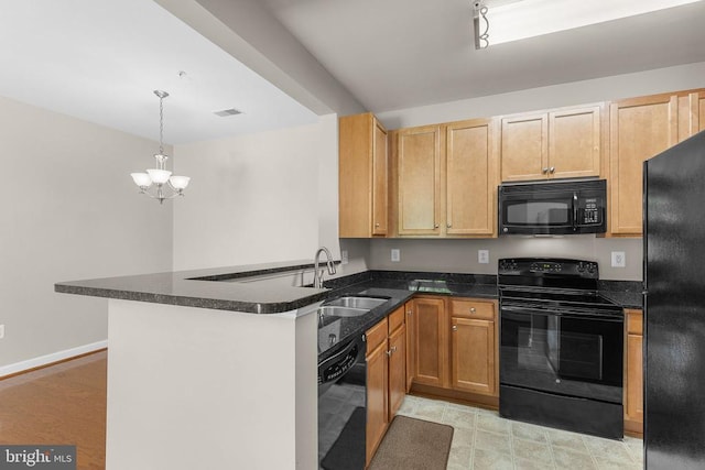  - kitchen with black appliances, a chandelier, a peninsula, hanging light fixtures, and dark stone countertops