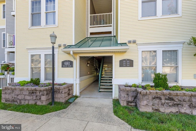 - property entrance featuring a standing seam roof, a metal roof, and a balcony