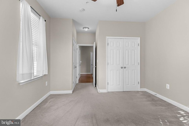  - unfurnished bedroom with carpet, a closet, multiple windows, and ceiling fan