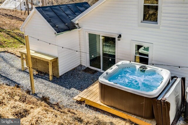 back of property with a hot tub