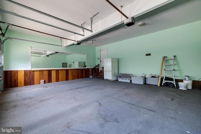 369 Eldon Yates Dr, Stanley, VA 22851 - garage featuring freestanding refrigerator, a garage door opener, wooden walls, and a wainscoted wall