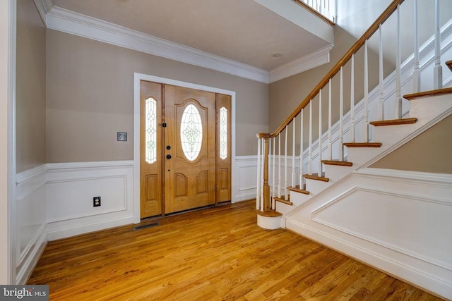 369 Eldon Yates Dr, Stanley, VA 22851 - entryway featuring crown molding, light wood-type flooring, a decorative wall, stairway, and wainscoting