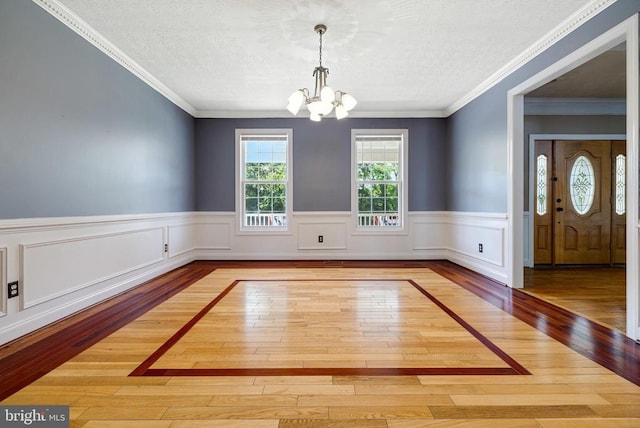 369 Eldon Yates Dr, Stanley, VA 22851 - unfurnished dining area featuring a chandelier, hardwood / wood-style floors, a wainscoted wall, a textured ceiling, and crown molding