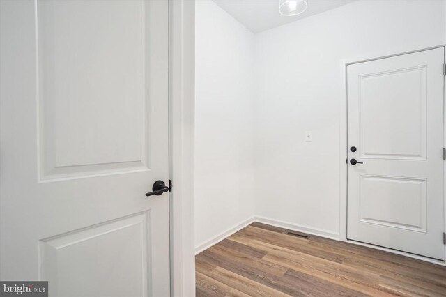  - doorway to outside with wood finished floors and baseboards