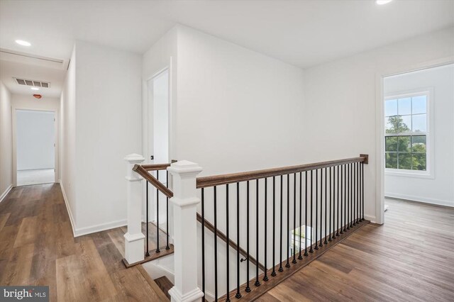  - corridor with an upstairs landing, wood finished floors, baseboards, and recessed lighting