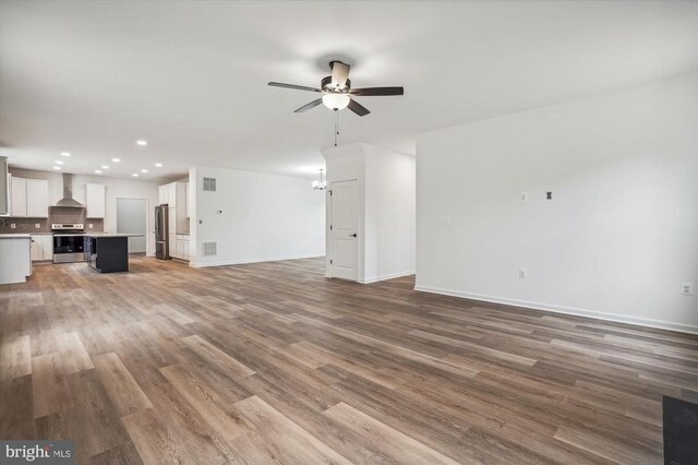  - unfurnished living room featuring a ceiling fan, recessed lighting, baseboards, and wood finished floors