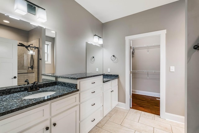 17 Mcilwee Ln, Staunton, VA 24401 - bathroom with double vanity, tiled shower, a spacious closet, and baseboards