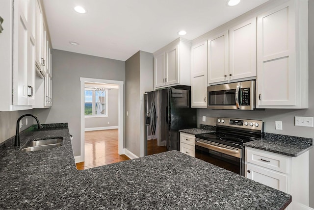 17 Mcilwee Ln, Staunton, VA 24401 - kitchen featuring stainless steel appliances, a sink, white cabinetry, wood finished floors, and dark stone countertops