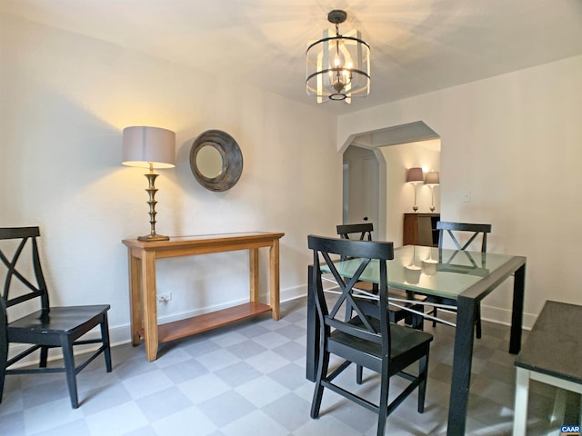239 Shamrock Rd, Charlottesville, VA 22903 - dining room with arched walkways, light flooring, a chandelier, and baseboards