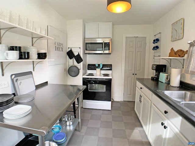 239 Shamrock Rd, Charlottesville, VA 22903 - kitchen with stainless steel microwave, range with electric stovetop, open shelves, and white cabinets