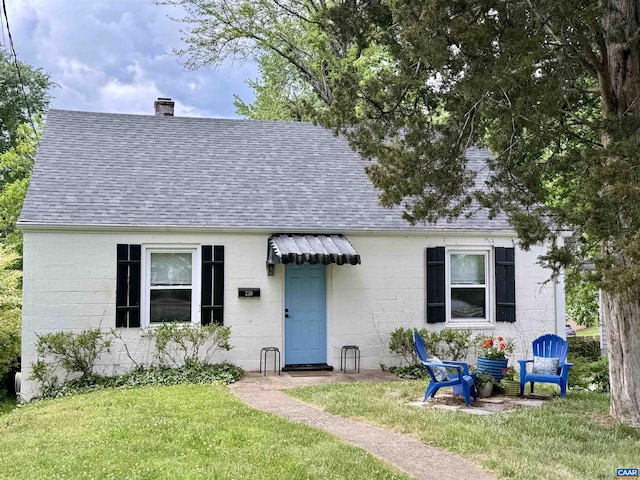 239 Shamrock Rd, Charlottesville, VA 22903 - view of front of home featuring a shingled roof, a chimney, a front lawn, and concrete block siding