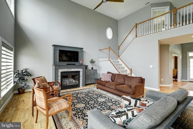12400 Eustace Dr, Bumpass, VA 23024 - living room with a towering ceiling, a ceiling fan, wood finished floors, a fireplace, and baseboards