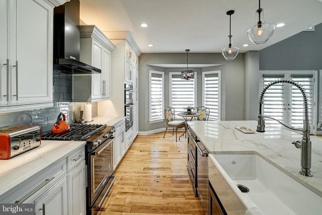 12400 Eustace Dr, Bumpass, VA 23024 - kitchen featuring wall chimney exhaust hood, a sink, stainless steel range with gas cooktop, recessed lighting, and light wood finished floors