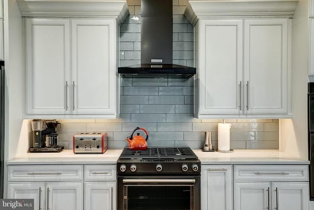 12400 Eustace Dr, Bumpass, VA 23024 - kitchen featuring black gas stove, wall chimney range hood, backsplash, and white cabinetry