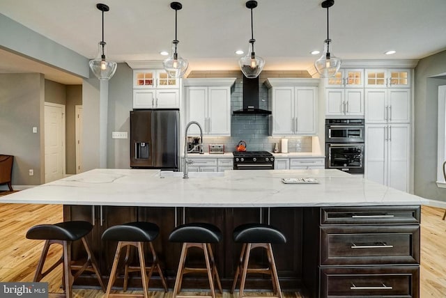 12400 Eustace Dr, Bumpass, VA 23024 - kitchen with black appliances, wall chimney range hood, a large island, white cabinets, and tasteful backsplash