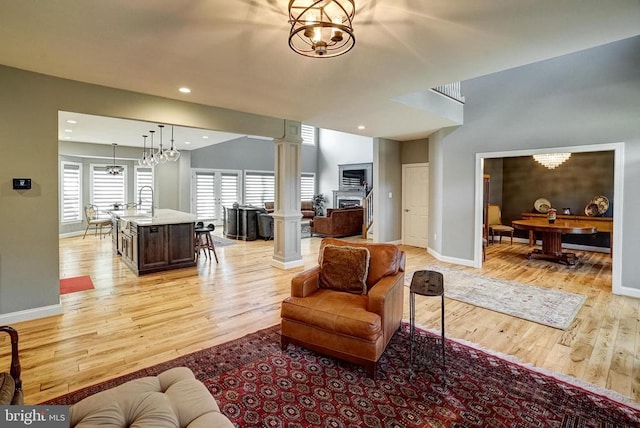 12400 Eustace Dr, Bumpass, VA 23024 - living area with light wood-type flooring, baseboards, recessed lighting, decorative columns, and a chandelier