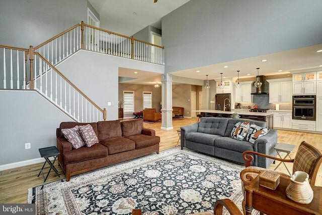 12400 Eustace Dr, Bumpass, VA 23024 - living area featuring ornate columns, light wood-style flooring, stairway, a high ceiling, and baseboards
