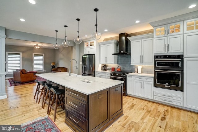 12400 Eustace Dr, Bumpass, VA 23024 - kitchen featuring wall chimney exhaust hood, refrigerator with ice dispenser, stainless steel range, a kitchen breakfast bar, and open floor plan