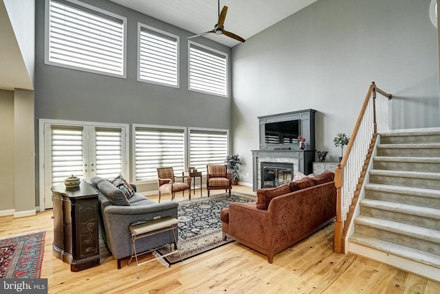 12400 Eustace Dr, Bumpass, VA 23024 - living room with high vaulted ceiling, ceiling fan, stairway, wood finished floors, and a glass covered fireplace