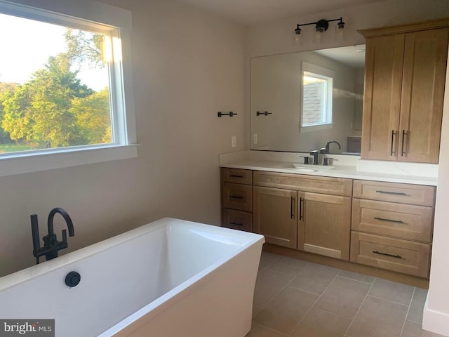full bathroom featuring tile patterned flooring, vanity, and a freestanding tub