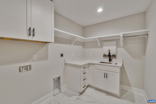 laundry room with a sink, cabinet space, marble finish floor, hookup for an electric dryer, and baseboards