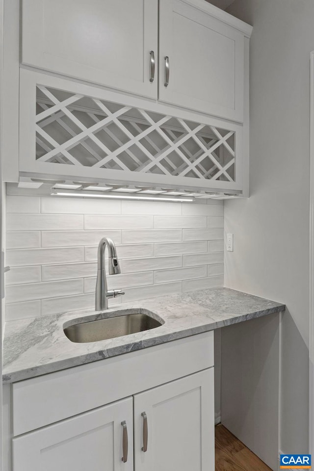 bar with decorative backsplash, bar area, and a sink