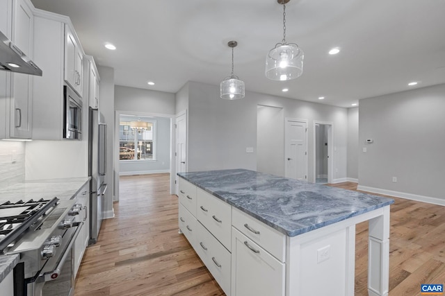 kitchen with baseboards, premium appliances, light wood-type flooring, and a center island